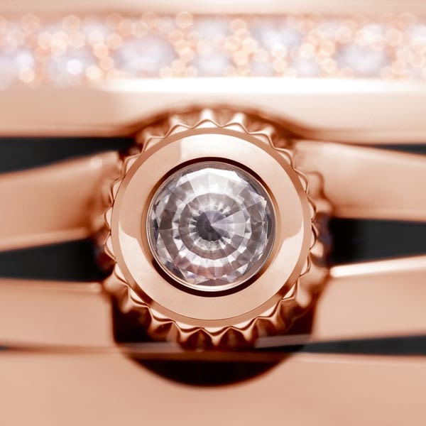 상감 세공 다이아몬드가 세팅된 레이디매틱 여성 시계의 골드 크라운 클로즈업